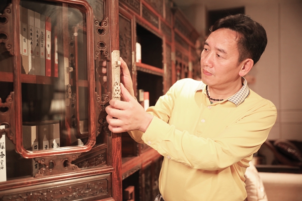 陳新平用心觸摸國方紅木家具，眼神里流露出對(duì)家具的喜愛與認(rèn)同